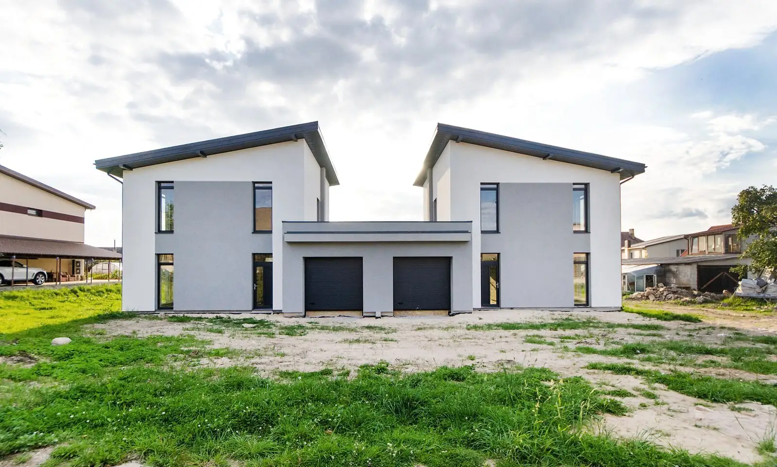 Duplex modern finalizat, cu fațadă albă, la lumina zilei